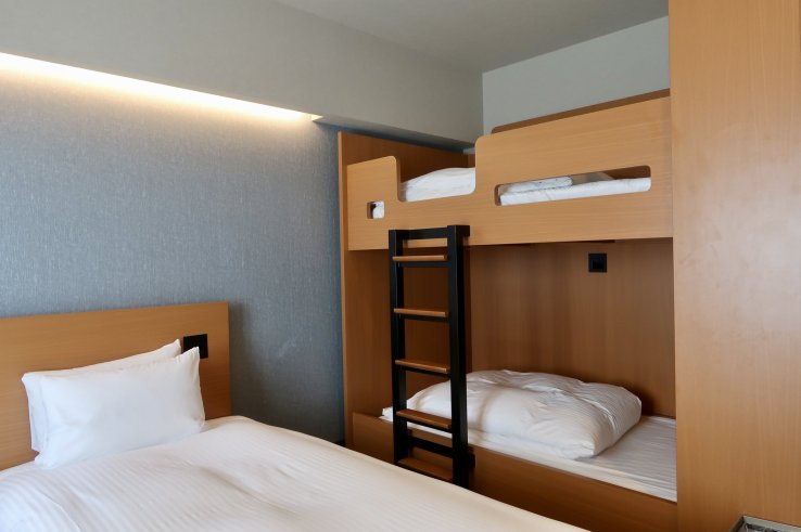 Room with two single beds and a bunk bed