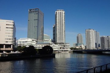 The view through the big clear window is of water and skyscrapers.