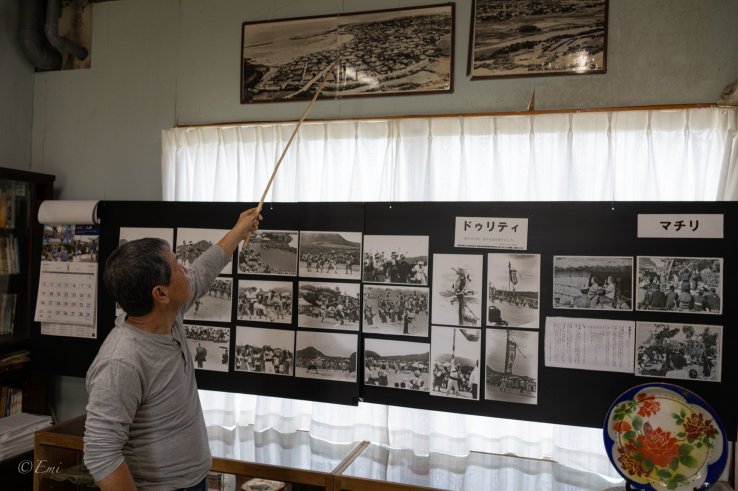 Mr. Ryuichi Ikema, a director of the folk museum, points at one of the archive photos of the Sonai region taken from the 85-meter-high cliff.
