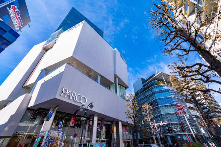 The exterior of Shibuya PARCO on a sunny day, towering into the blue sky
