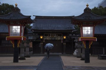 <p>The girl with the umbrella looks very small in comparison with the impressive red lanterns.</p>