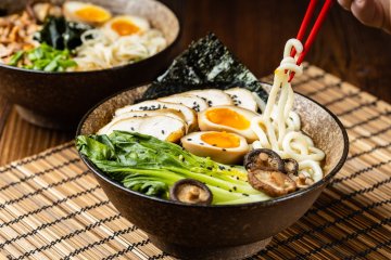 A bowl of ramen with chopsticks