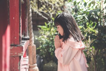 A young girl praying at a temple