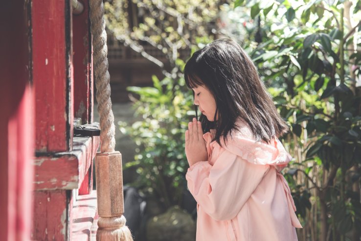 A young girl praying at a temple