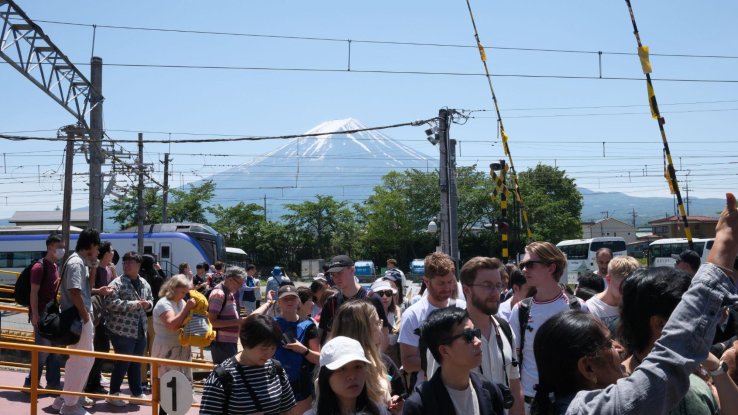 A crowd of people with Mt. Fuji in the background