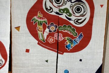 <p>A daruma-themed noren indicating that it is a shop dealing in traditional items (2013)</p>