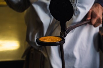 Handmade senbei in an iron mold