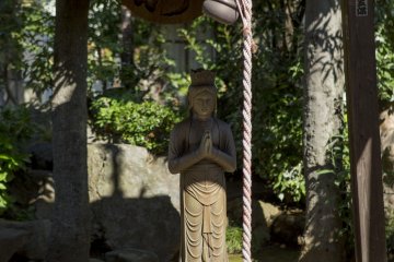 <p>This statue of Amida caught my eye, as it appeared to seek shelter from the sun</p>