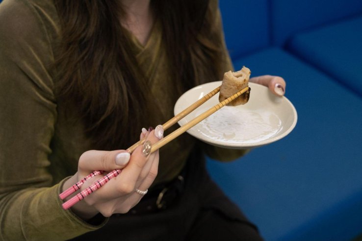 Trying the chikuwa fish cake in Yamatoku Hiratsuka Suisan’s oden