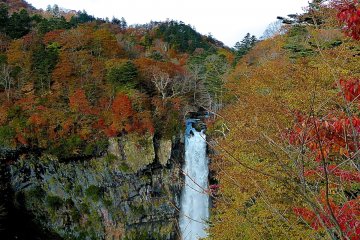 Blue sky and colorful leaves surround the falls