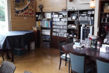 <p>Lots of CDs and sheet music sit behind the piano</p>