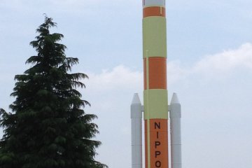 In front of the museum, a Japanese rocket stands next to a map of Japan on an massive orb