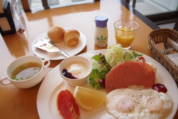 <p>The Western breakfast option: a scrumptious spread of breads, ham, eggs, yogurt, fruit and cabbage soup.</p>