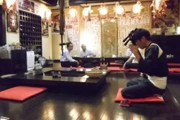 <p>The jamisen player gets ready to start his performance</p>