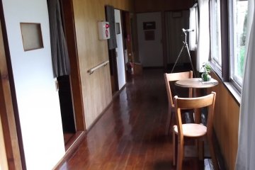 <p>The corridor on the mens' side of the hostel: rooms on the left, bathroom at the end</p>
