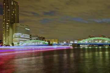 <p>Ships pass by and below&nbsp;Kachidoki Bridge at night-time</p>