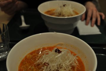 Ramen putih berkuah pedas dengan taburan wijen, irisan daun bawang yang banyak dan tauge