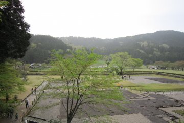 Ruins of the Asakura family residence viewed from one of the gardens above. Idyllic fields and mountains are in the background