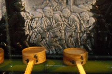 Yamakasa racers carved into water basin.