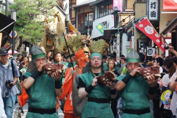 The dragon warriors march along Nanenzaka, playing traditional music. You can see Seiryu-e in the background.
