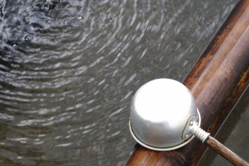 <p>The purification font. Many temples use cheap plastic cups, but this is an older type with wooden handle and tin cup</p>