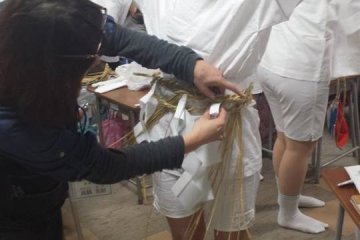 Mengenakan pakaian tradisional terasa lebih berat daripada yang terlihat, dan bahkan terkadang membutuhkan bantuan orang