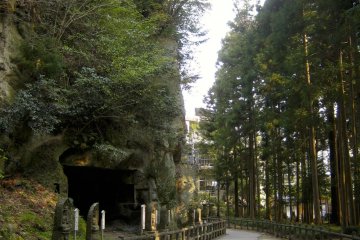 Path adjacent to the shear rock wall with ancient cave shrines.