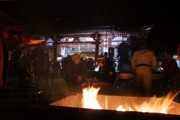 <p>Huddle around the bonfire in front of the shrine to keep warm</p>