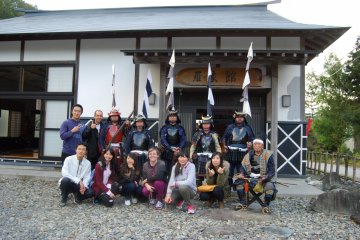 <p>Matchlock Rifle Brigade members and travelers pose for the camera in front of Sumita town community hall.</p>