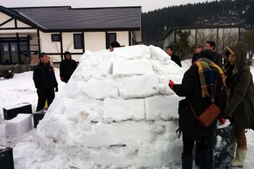 <p>Topping off the igloo is the hardest part. Snow often fell inside the structure or was dropped before it could be hoisted into position.</p>