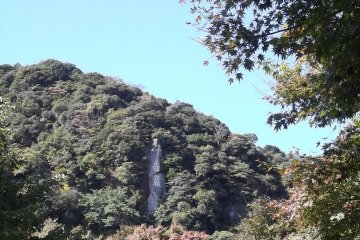 <p>There's a rock in the hill with large kanji characters carved into its face</p>